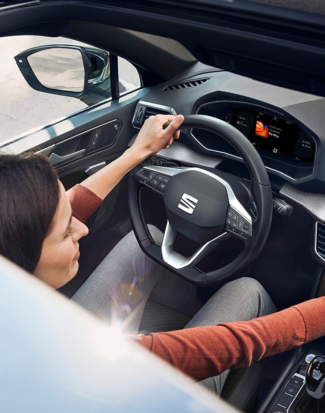 Interior view of a man opening a new SEAT Tarraco XPERIENCE with new upholstery seats 