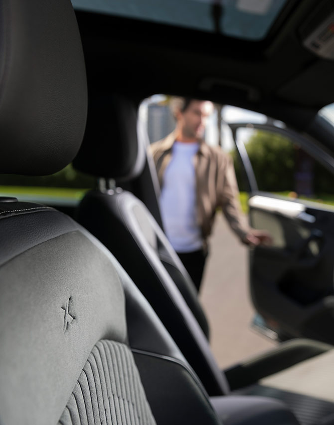 Sisänäkymä miehestä, joka avaa uuden SEAT Tarraco XPERIENCE -mallin, jossa on uusi istuinverhoilu