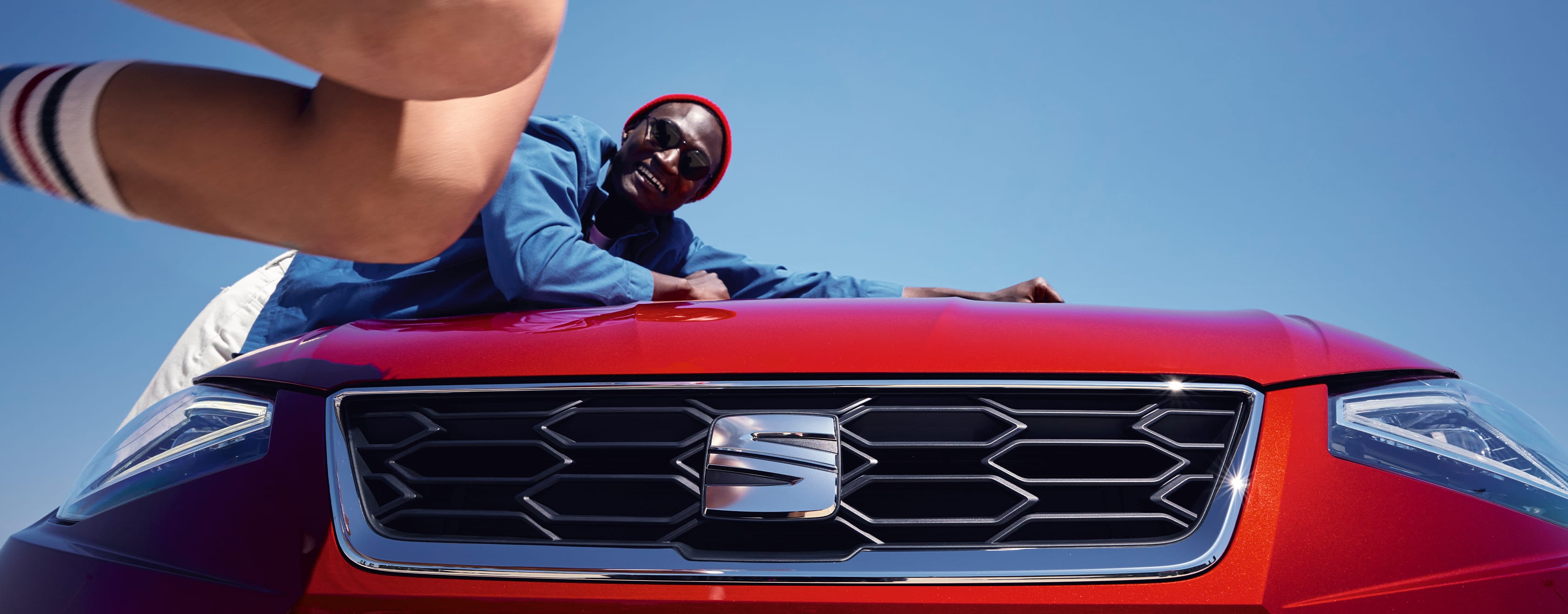 Mies nojaa Desire Red -värisen SEAT Ibizan konepeltiin