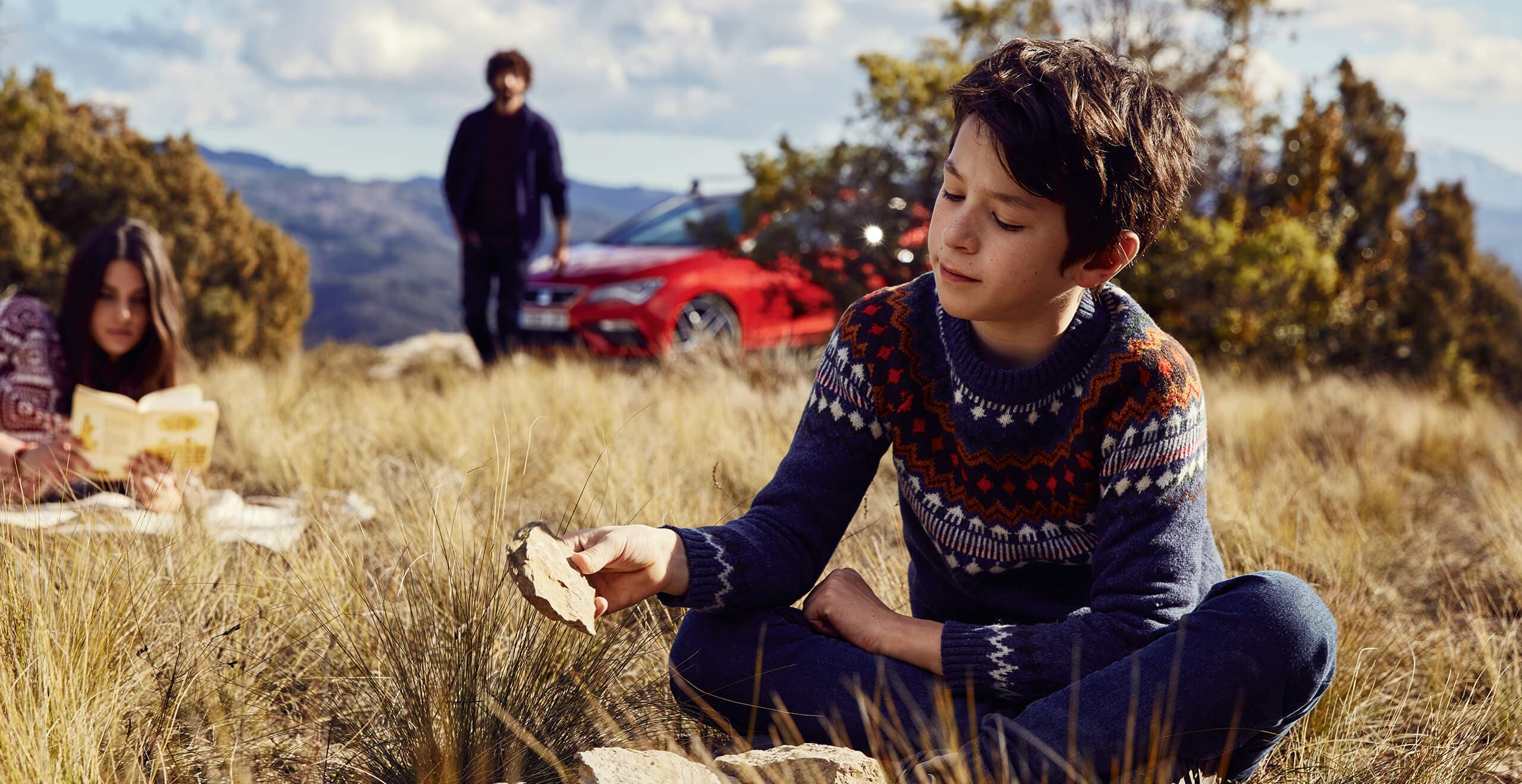 Servizi e manutenzione per vetture nuove SEAT – Un ragazzo con un sasso in mano davanti a una SEAT Leon